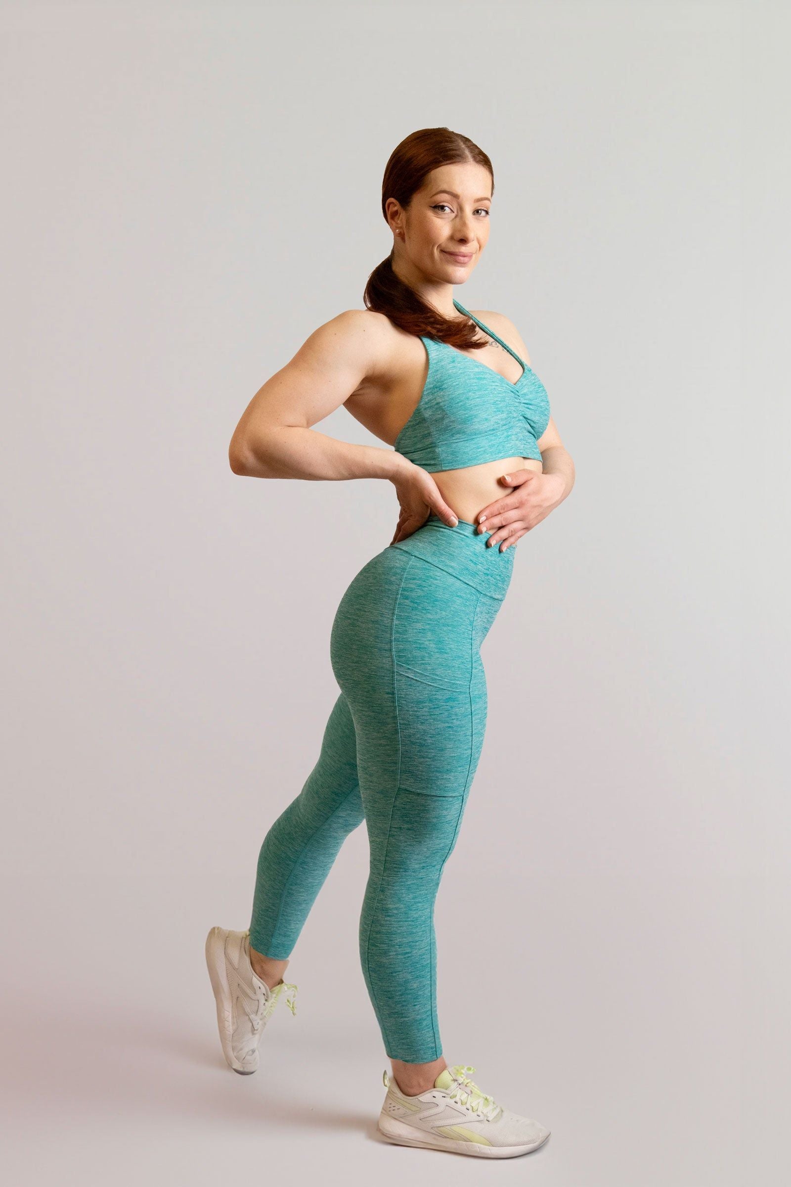 Mannequin de 3/4 portant la brassière et le legging bleu turquoise de chez InProcess