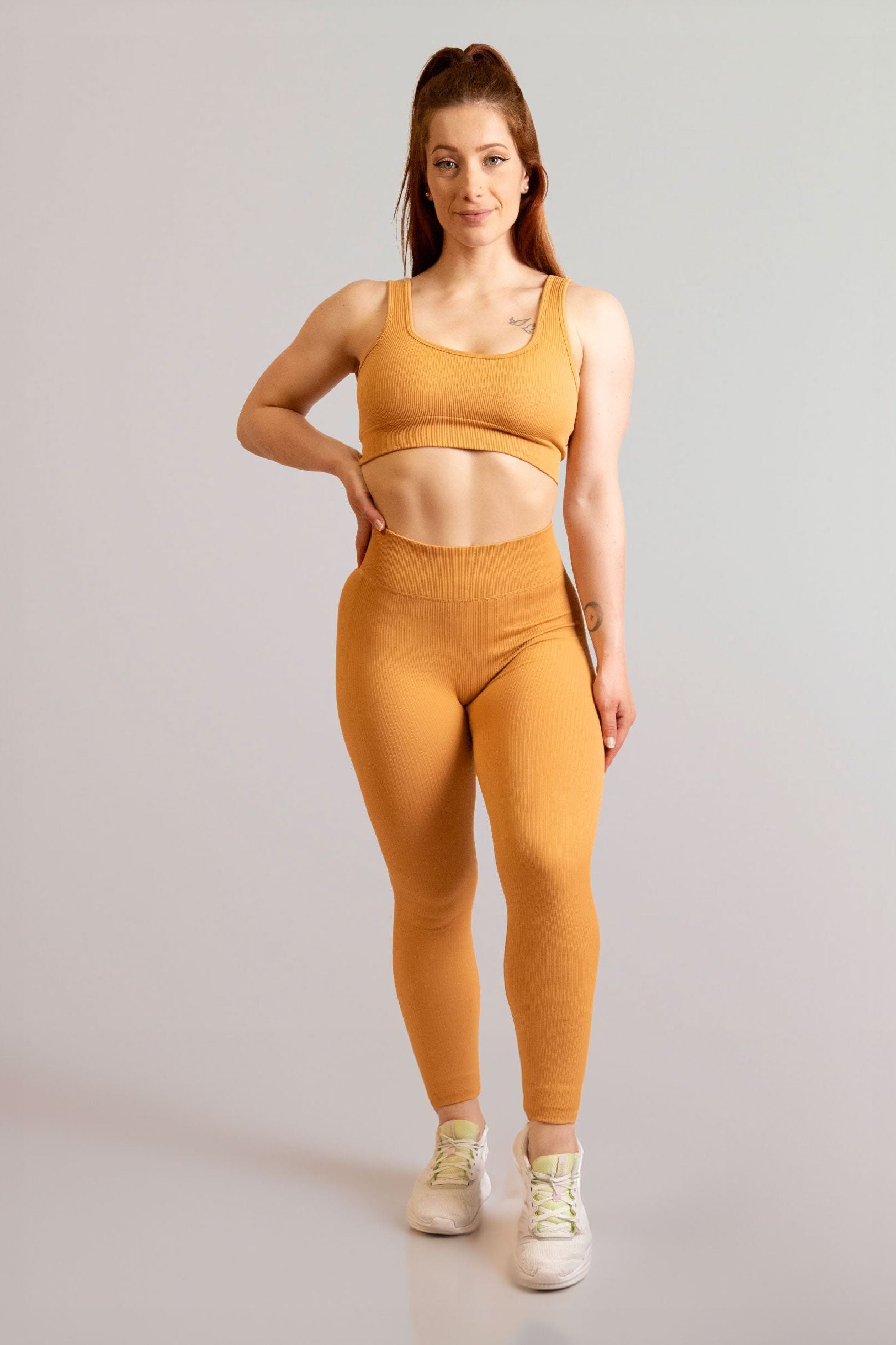 Mannequin de face portant la brassière et le legging moutarde de chez InProcess