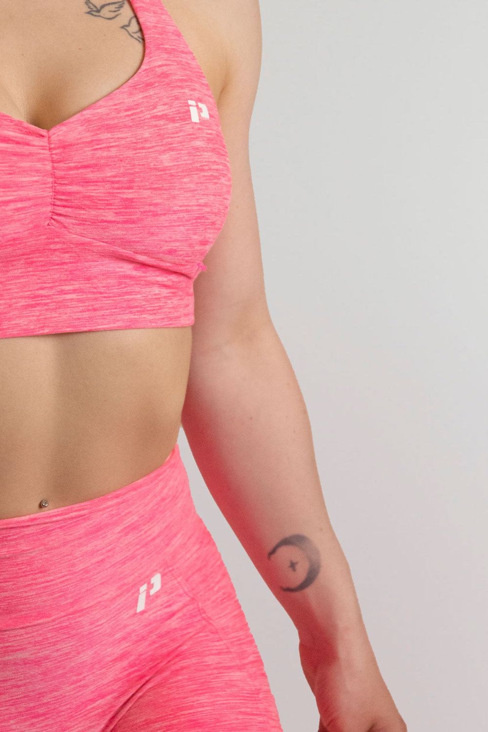 Mannequin de 3/4 portant la brassière et le legging rose de chez InProcess